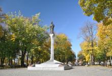 Kolumna Zygmunta Augusta na tle jesiennego parku,przy kolumnie jest kilka spacerujących osób, fot. J. Koniecko