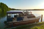 Photo shows white and red boat on the water with bikes on it.