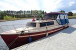 Photo shows white and red boat on the water with bikes on it.